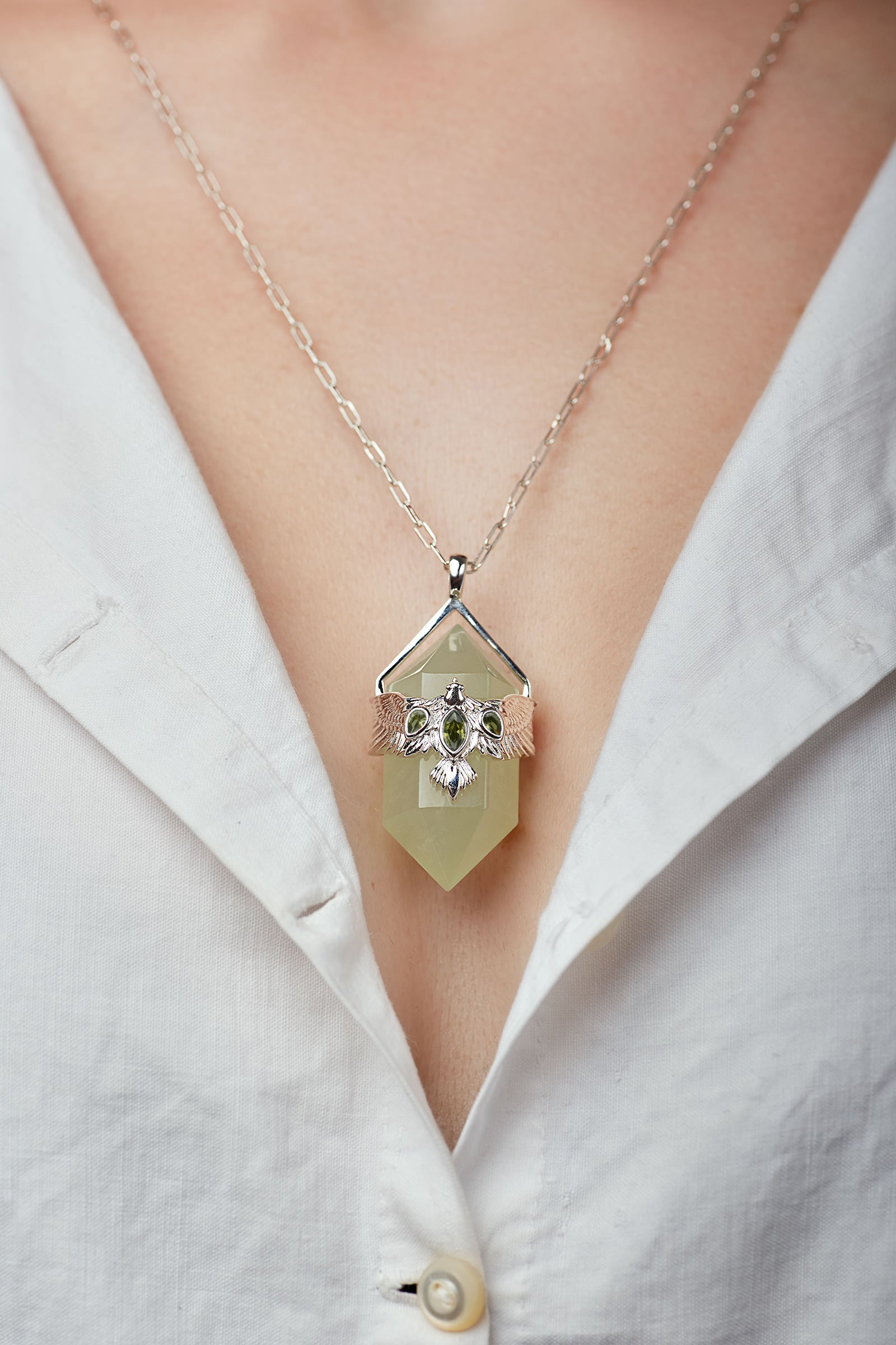 Necklace with a pendant worn by a person in a white shirt