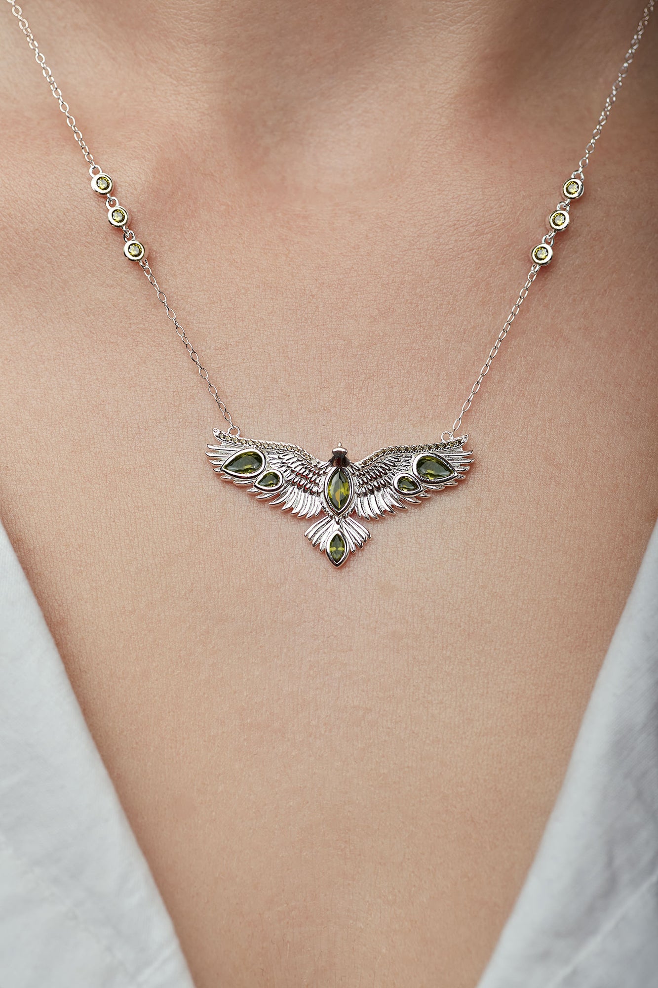 Silver bird necklace with an eagle pendant on a person's neck