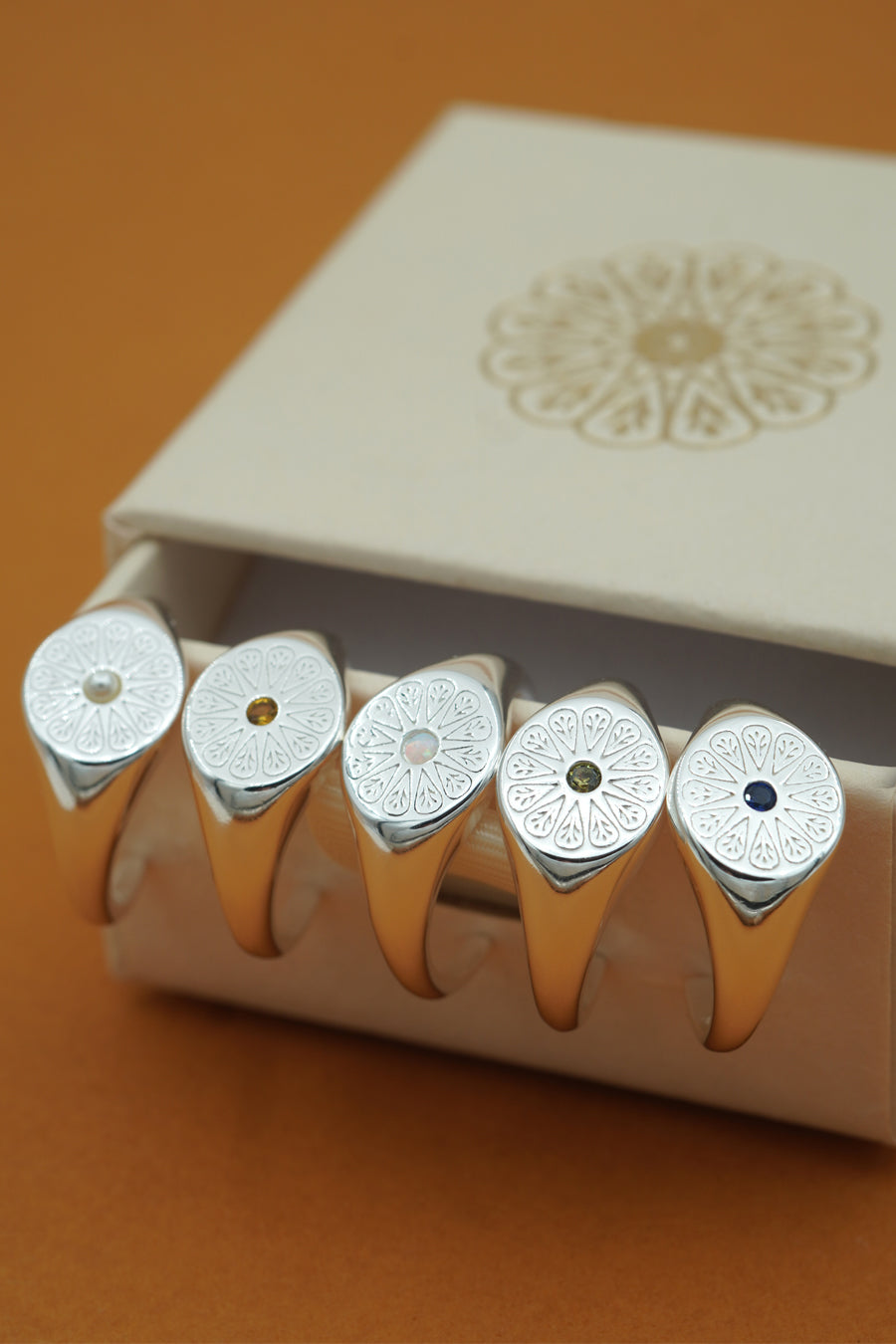 Silver July Ruby Signet Birthstone Ring stacked on side of box