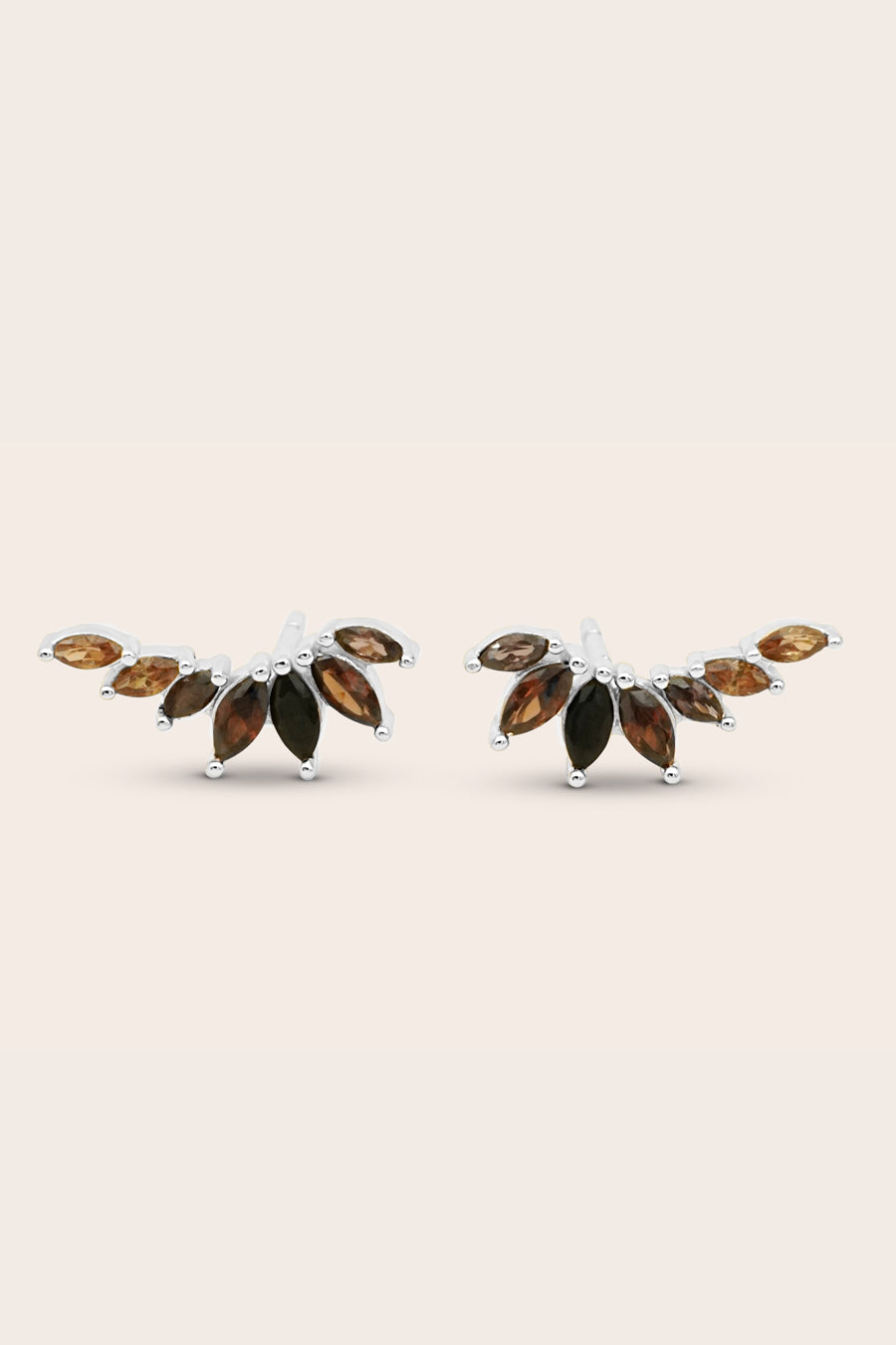 Pair of earrings with brown gemstones on a beige background