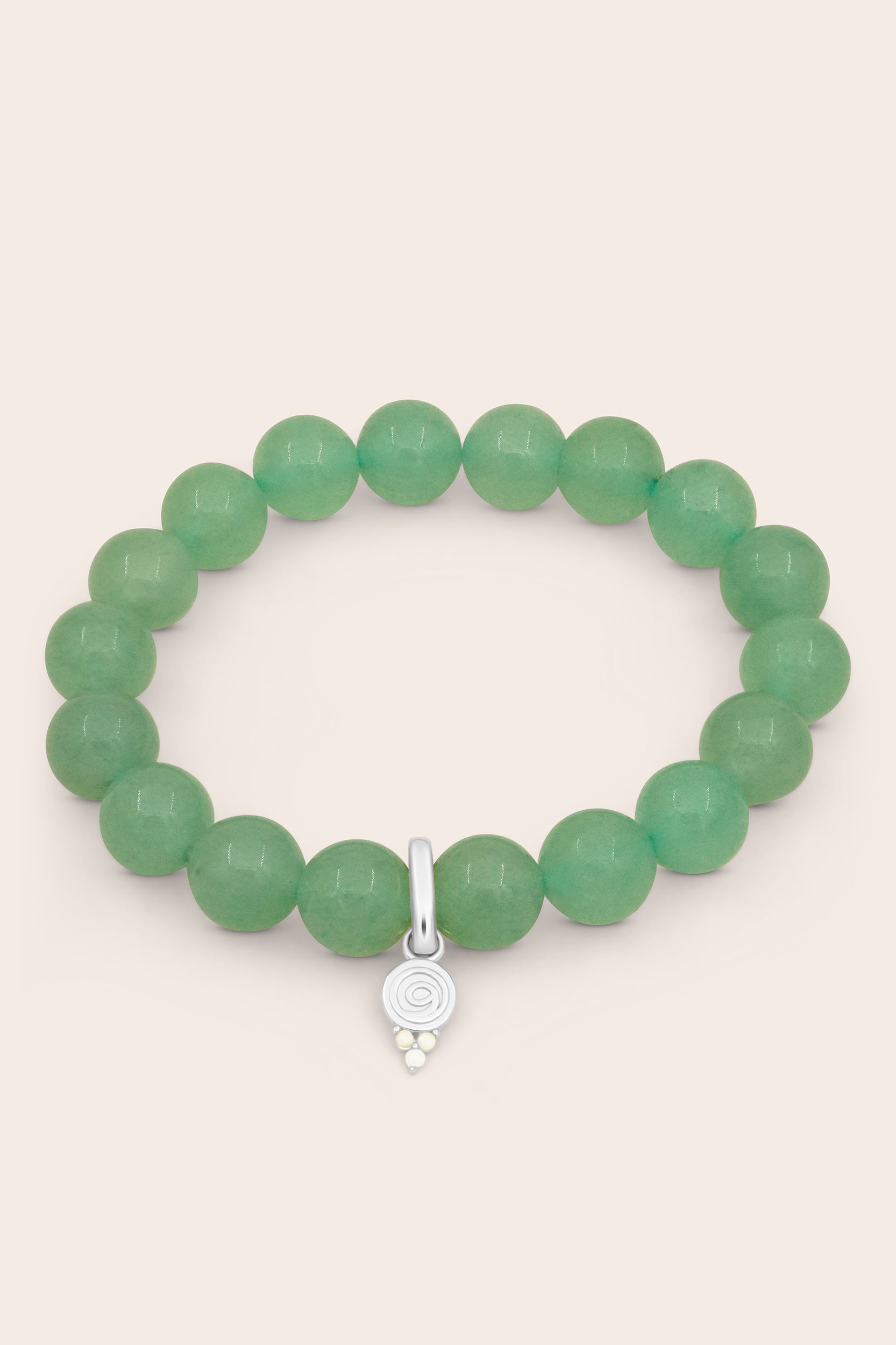 Green crystal layering beaded bracelet with a silver gratitude charm on a beige background