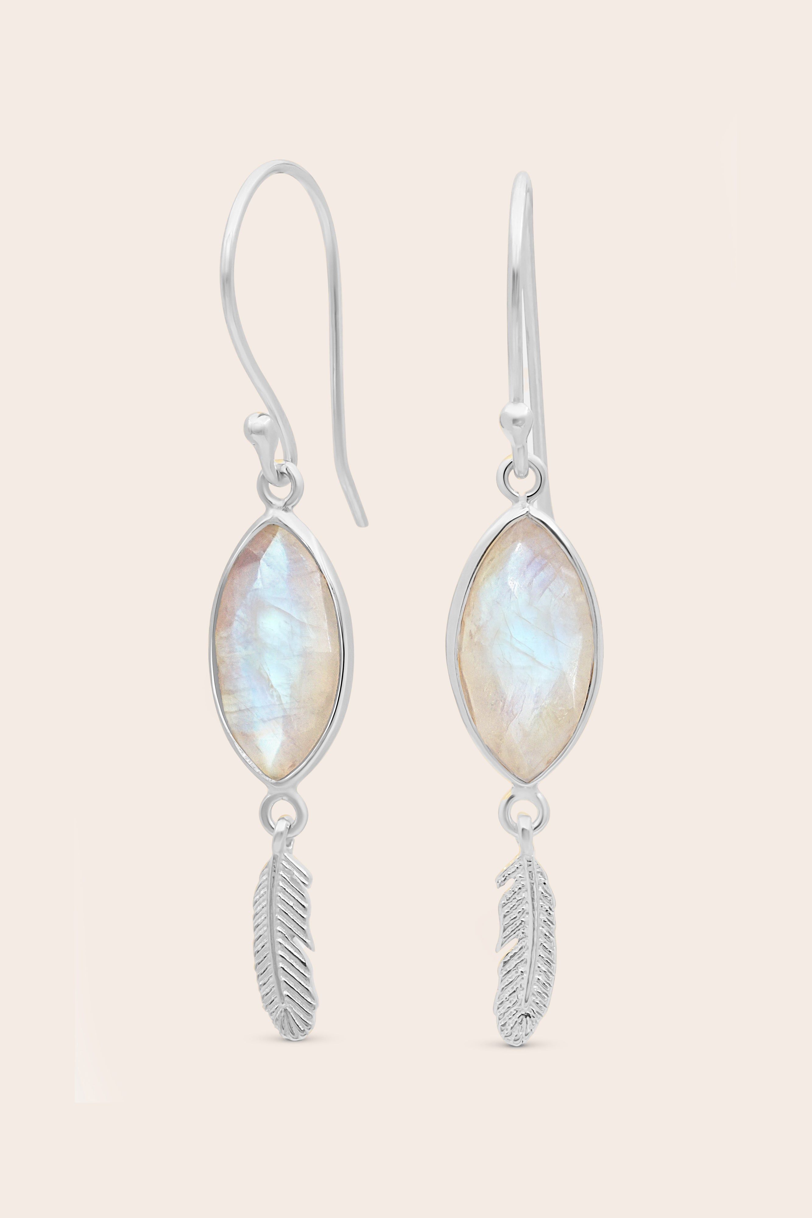 Pair of earrings with moonstone stones and feather designs on a light background