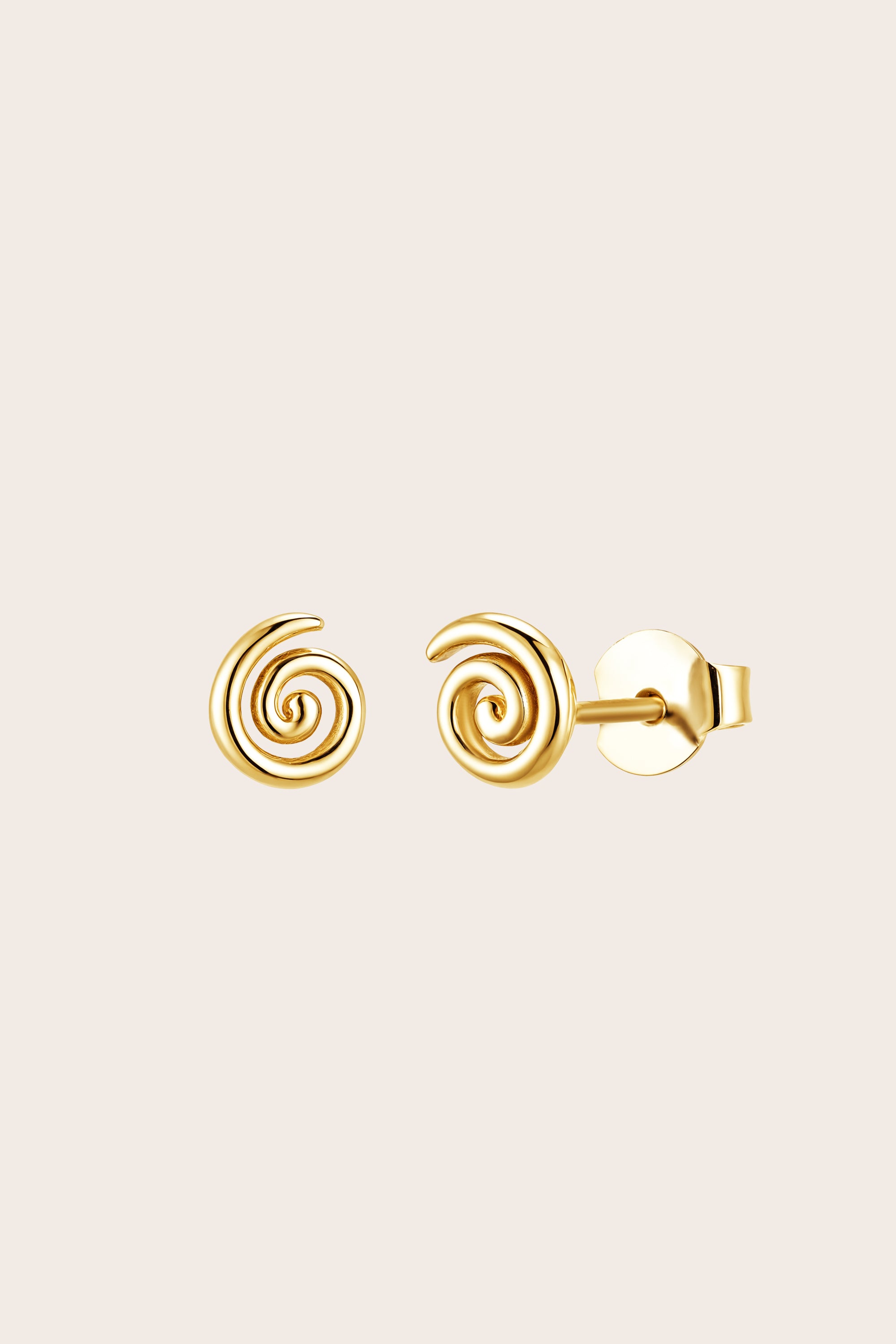 Gold spiral koru fern earrings on a beige background