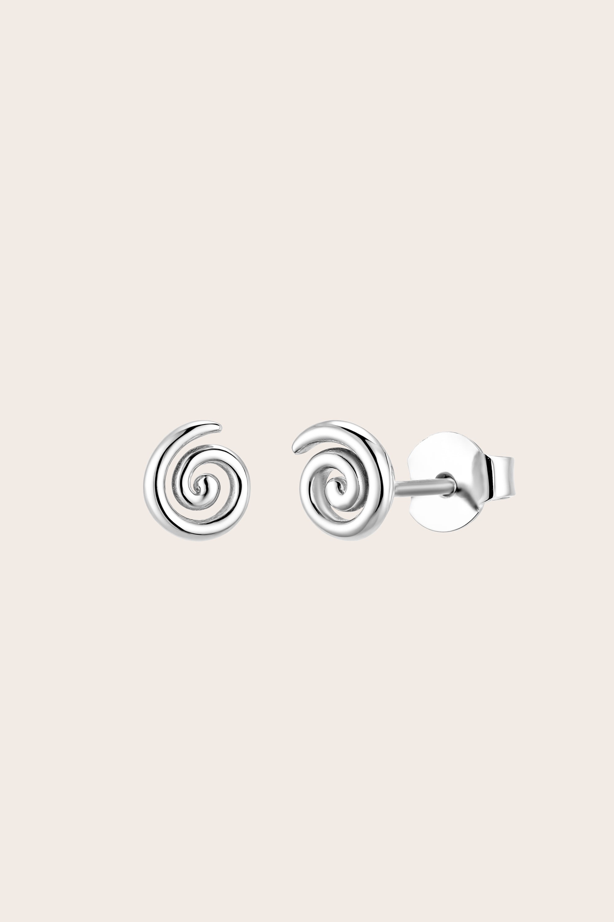 Silver spiral fern koru stud earrings on a light pink background
