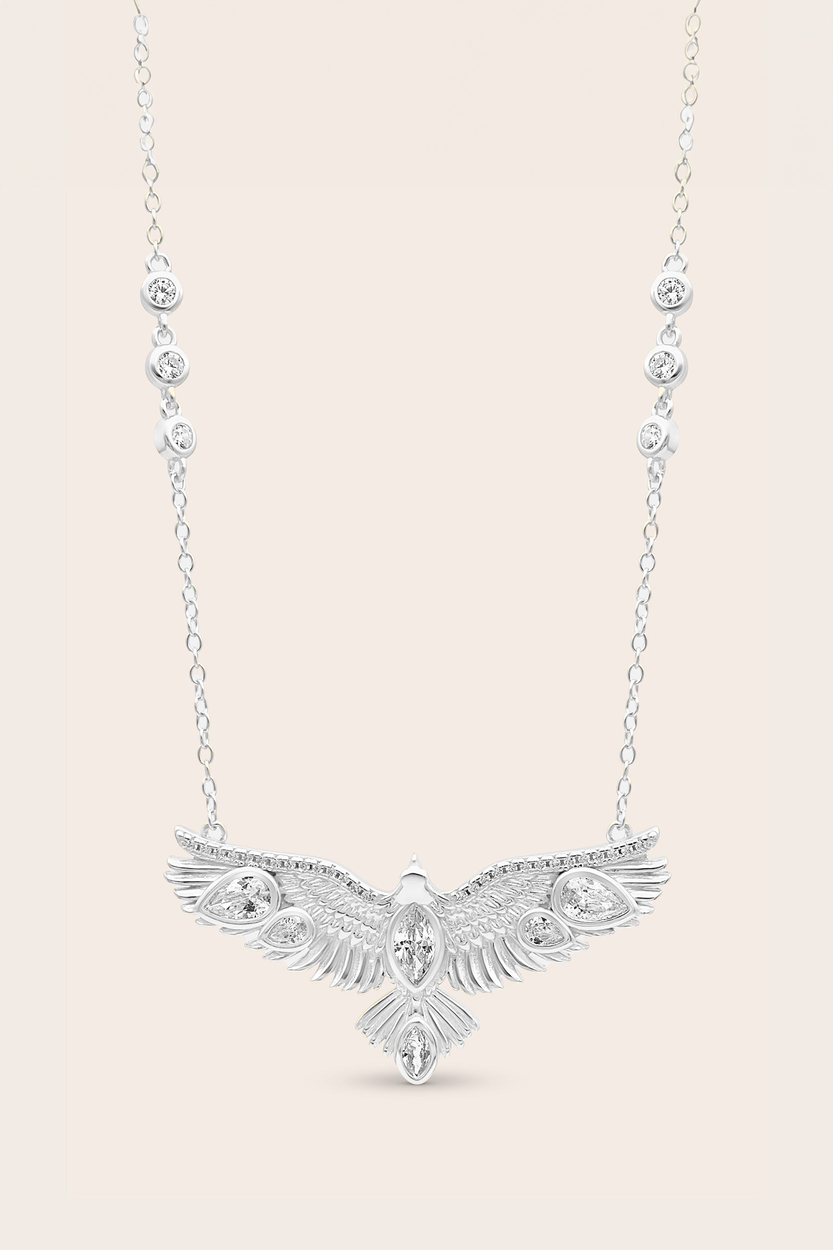 Silver eagle pendant necklace on a light beige background