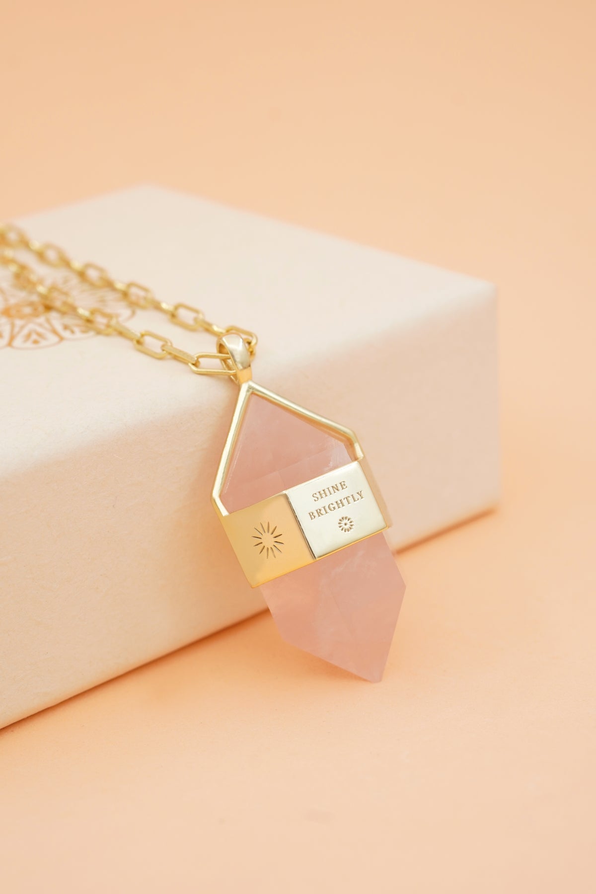 Rose Quartz Pendant Necklace on peach background
