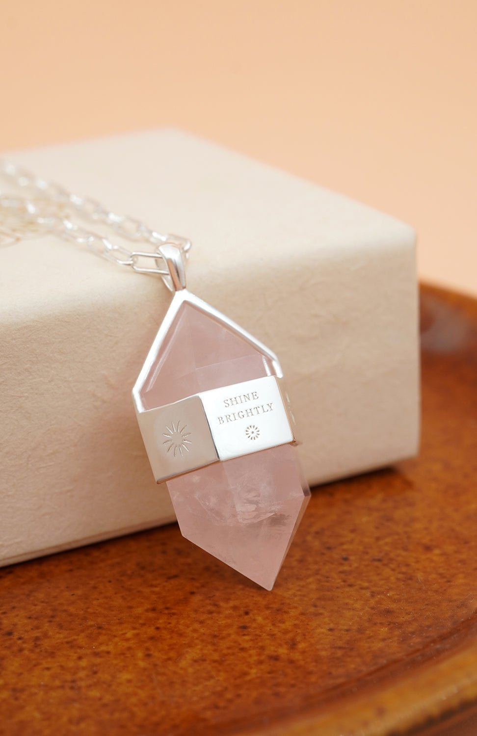 Silver Rose Quartz Pendulum Necklace on cream box