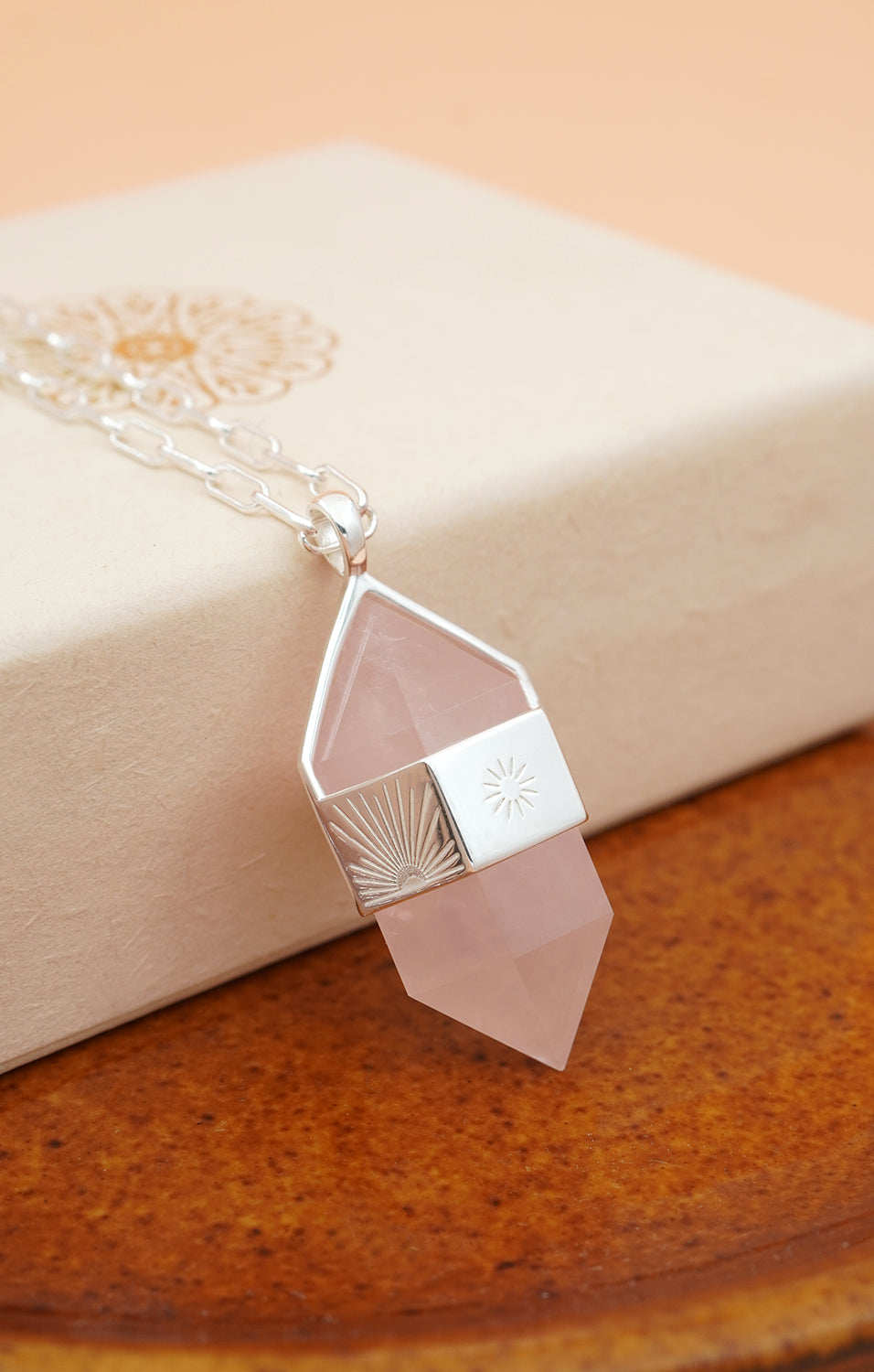 Silver Rose Quartz Pendulum Necklace on cream box