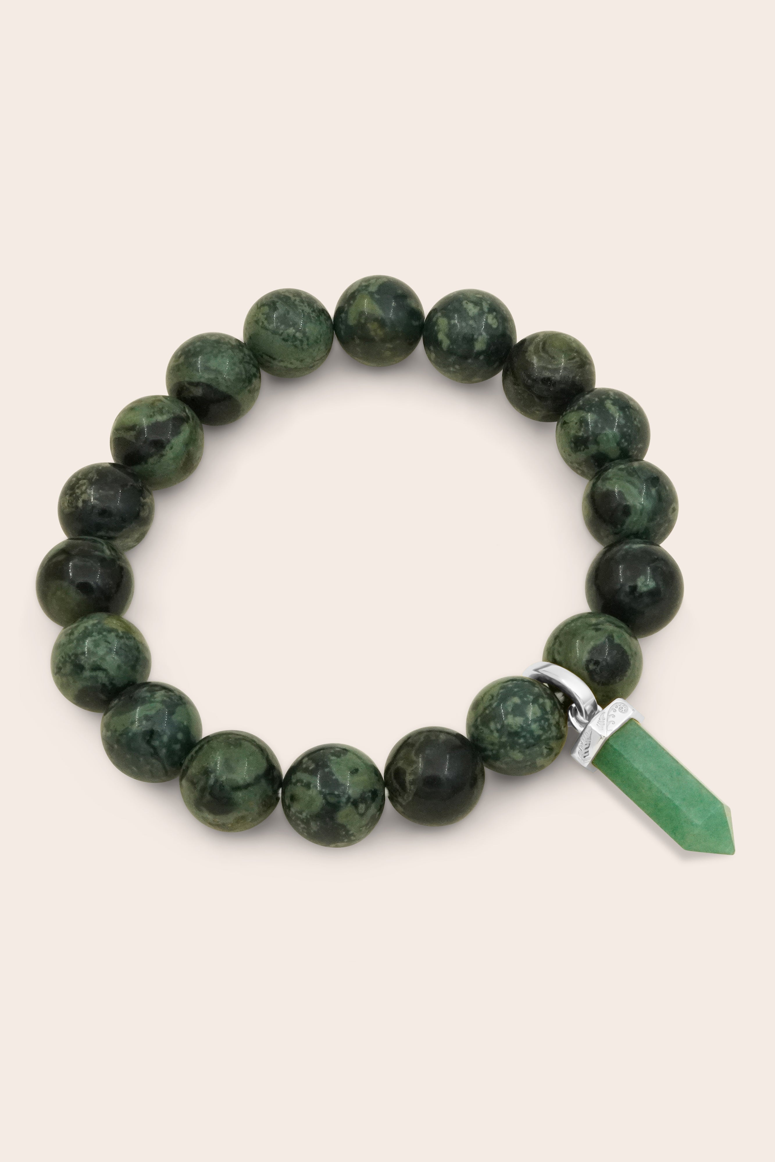 Green jasper crystal beaded bracelet with a silver and green aventurine charm on a beige background
