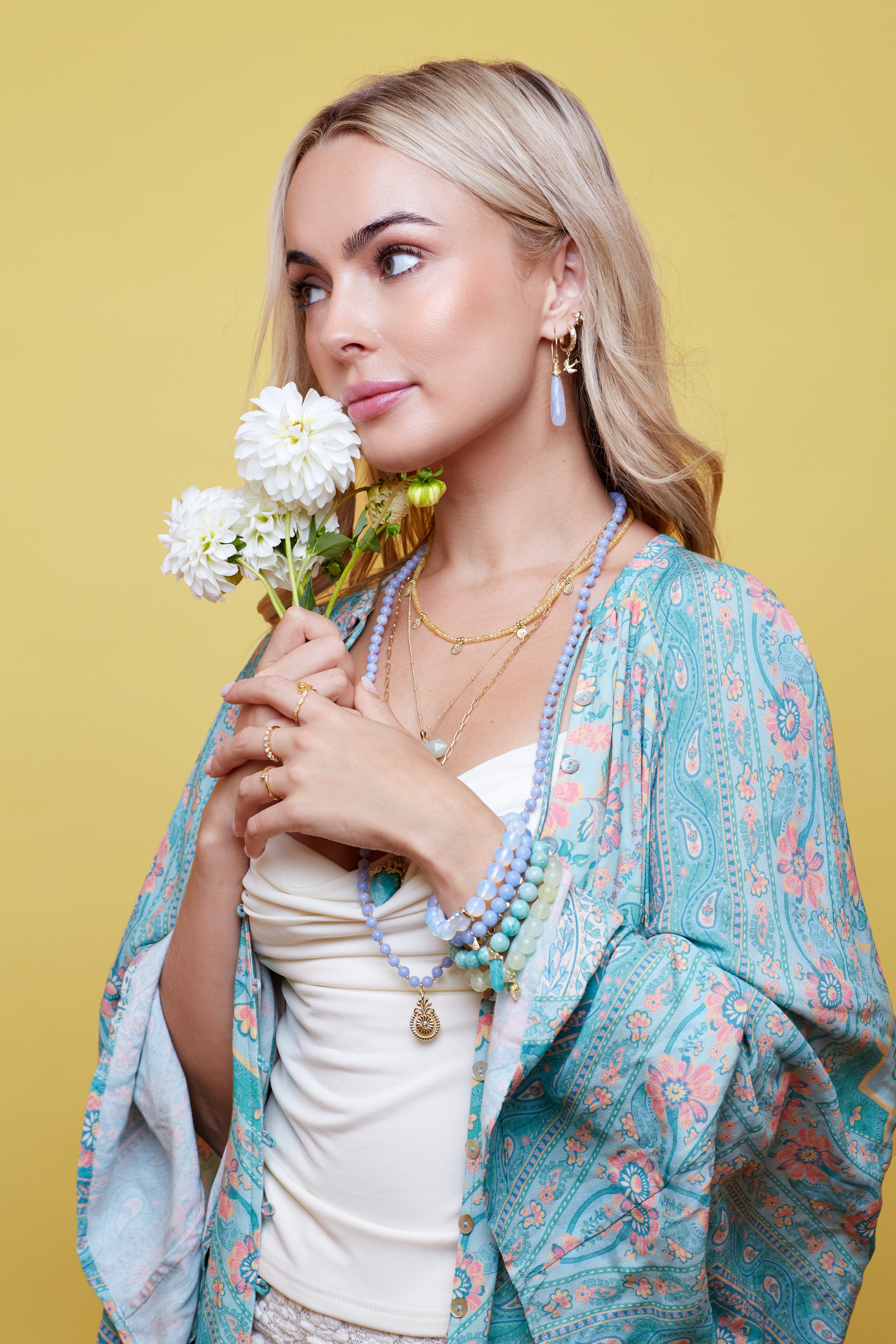 Woman holding flowers against a yellow background