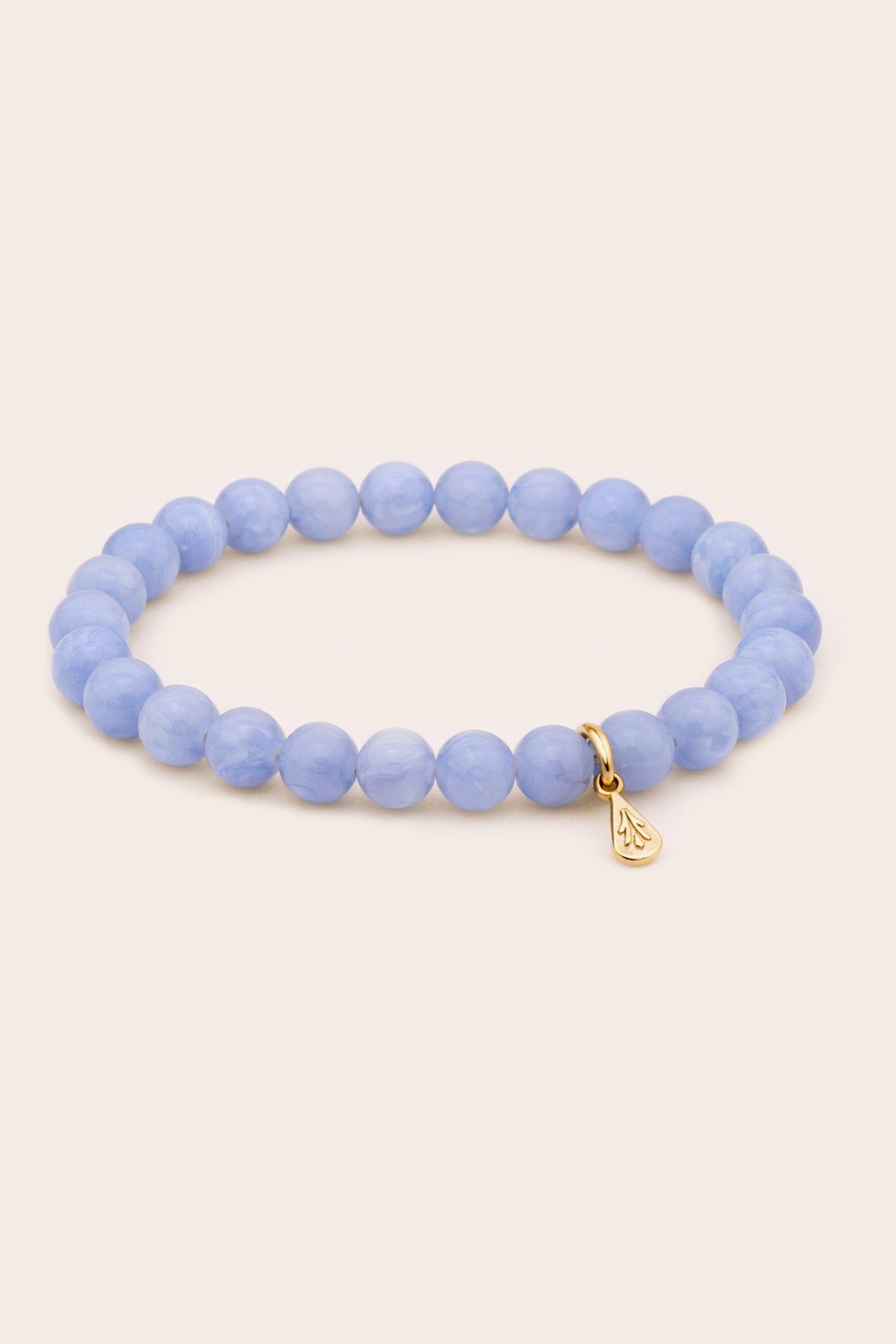 Blue beaded bracelet with a gold charm on a white background