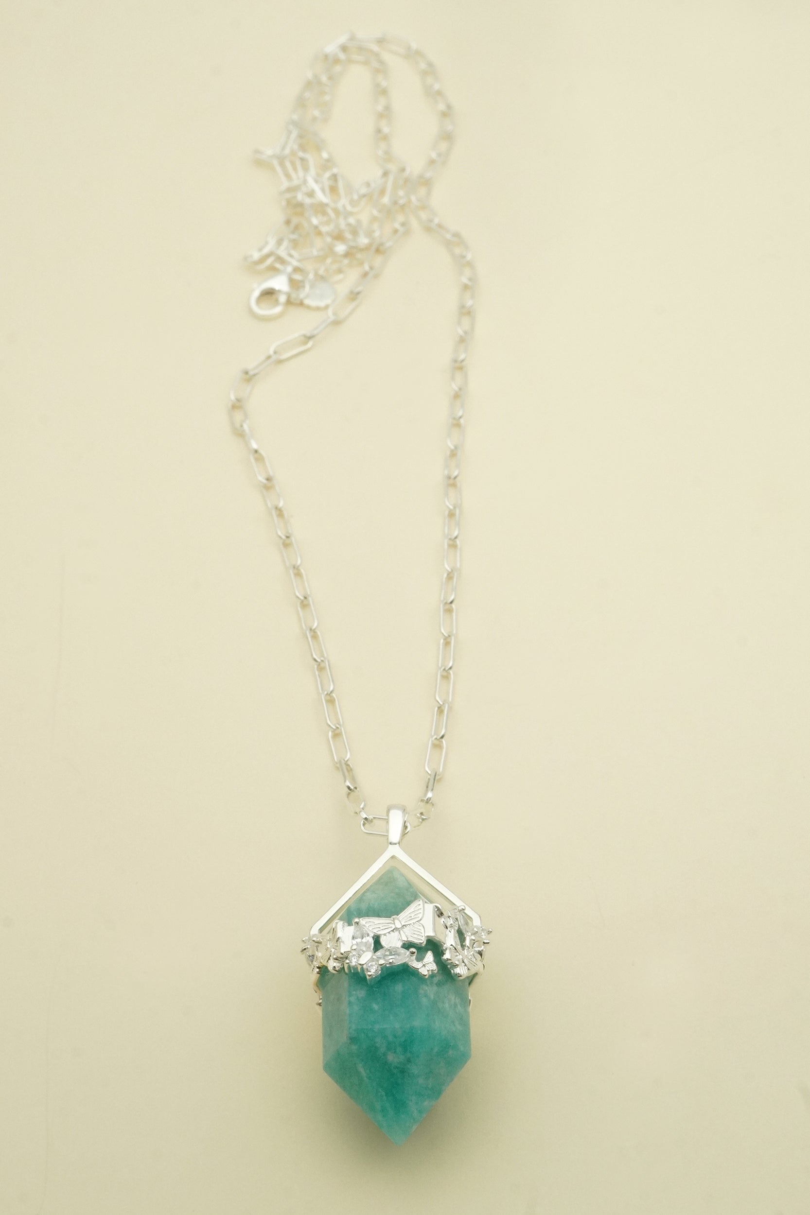 Necklace with a green amazonite crystal pendant on a beige background