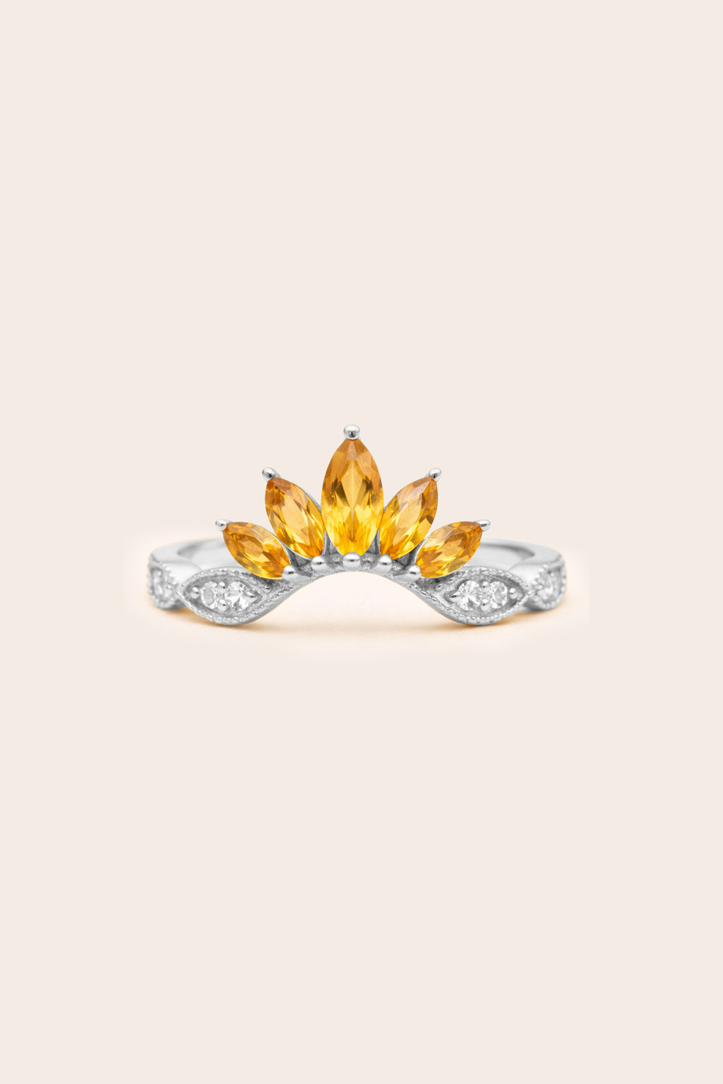 Silver ring with yellow citrine gemstones on a beige background
