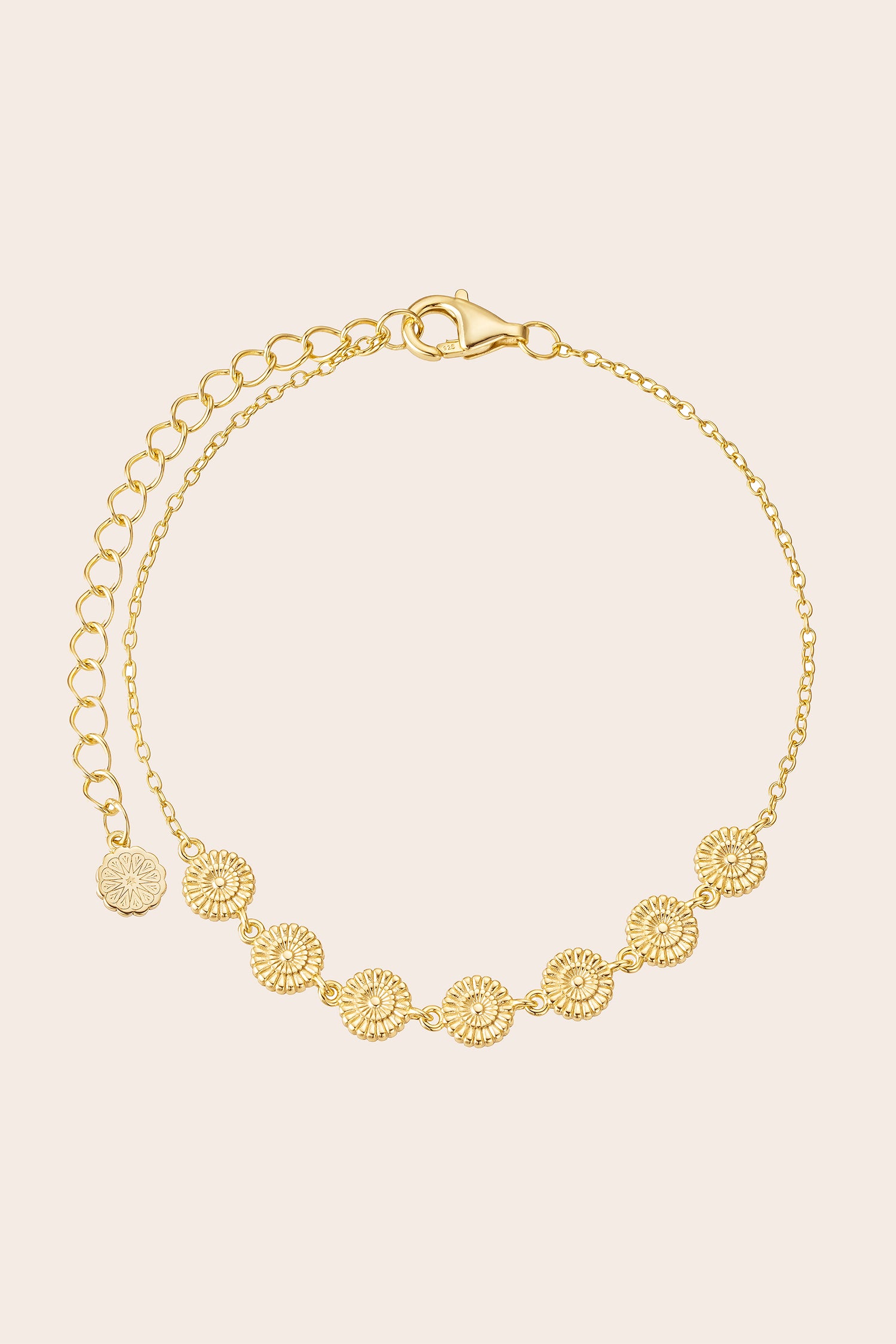Gold bracelet with floral patterns on a beige background
