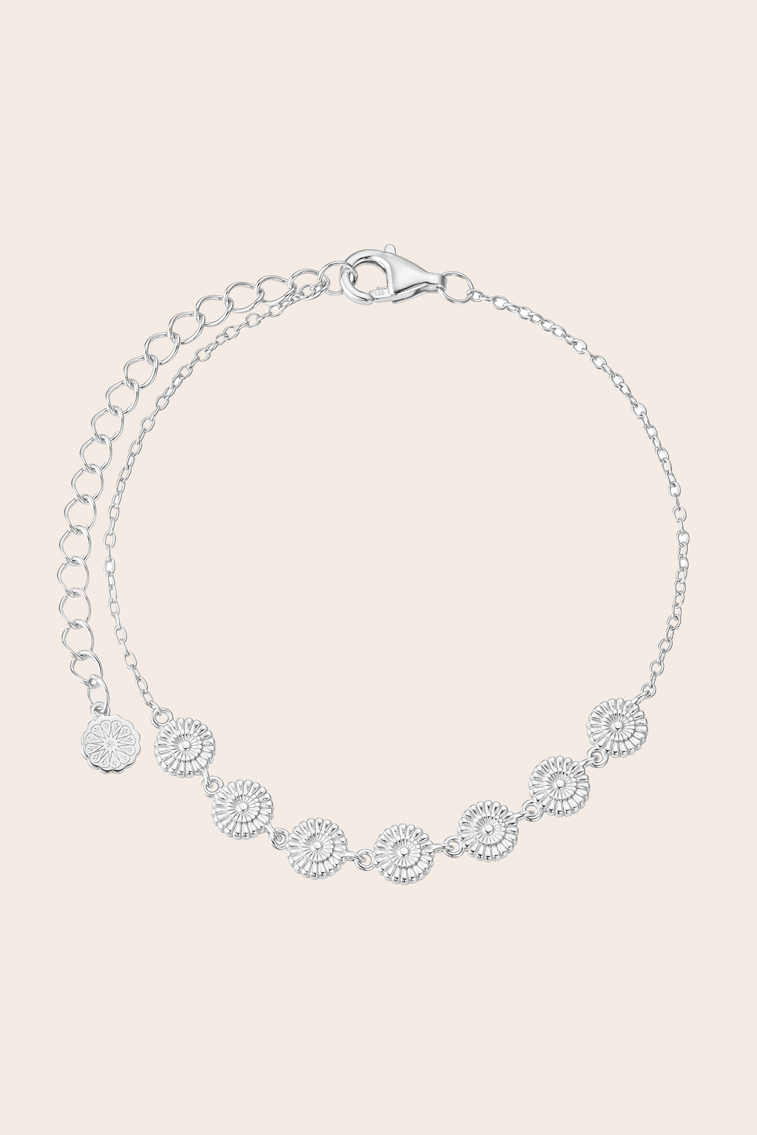 Silver flower bracelet with floral designs on a light pink background