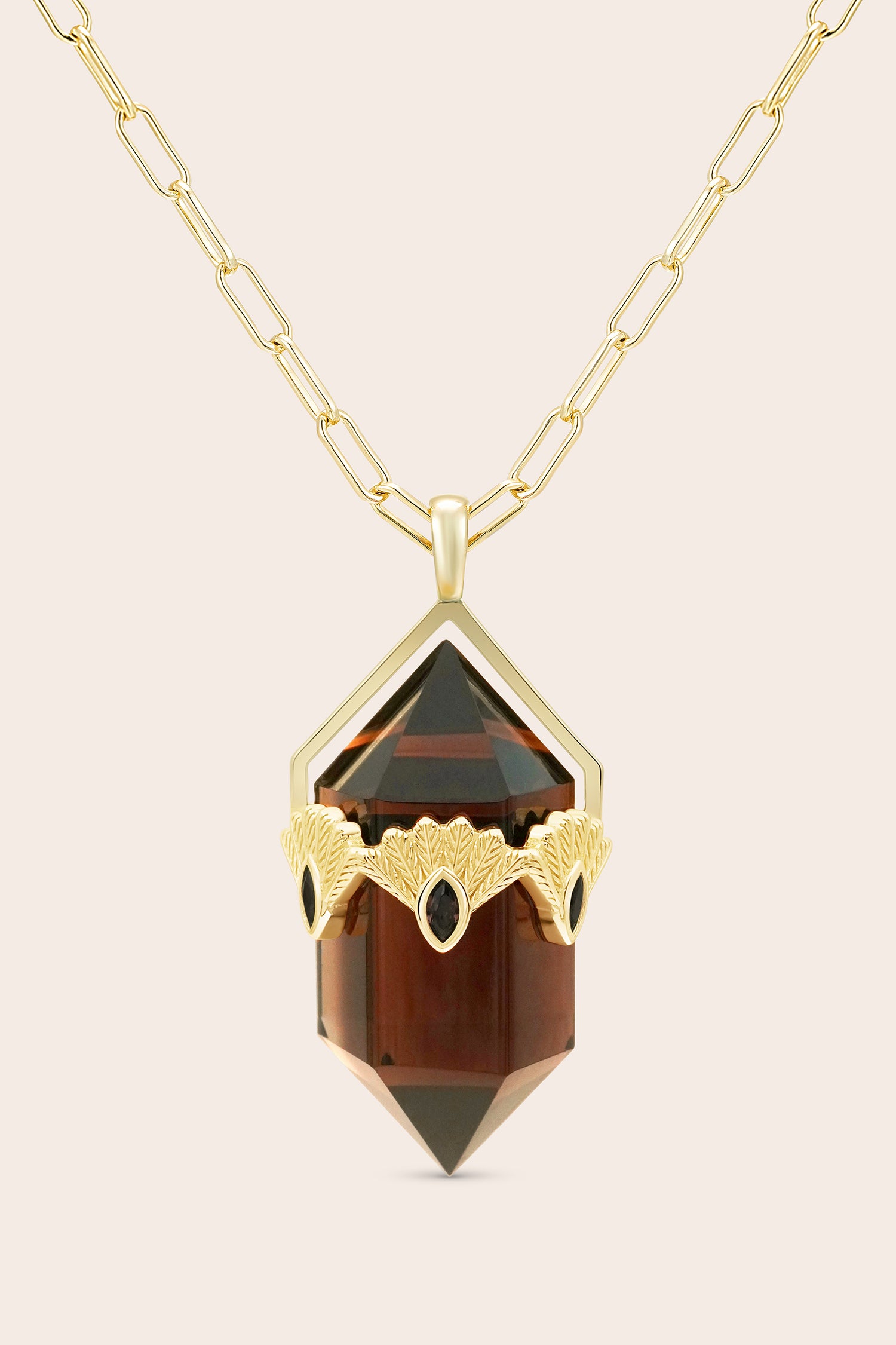 Gold fantail necklace with a brown smoky quartz gemstone pendant on a beige background