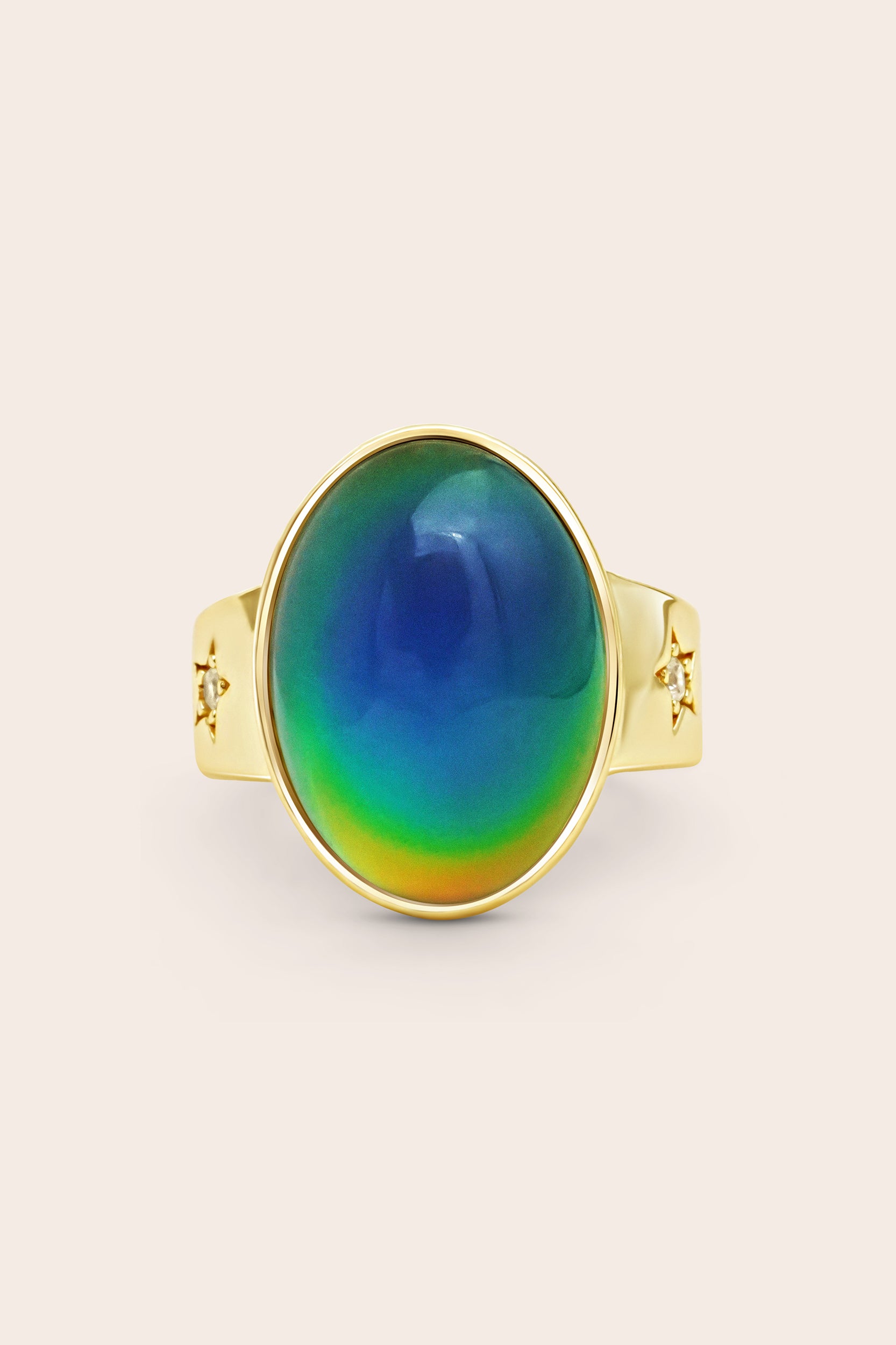 Gold Mood Ring with a colourful stone on a light beige background