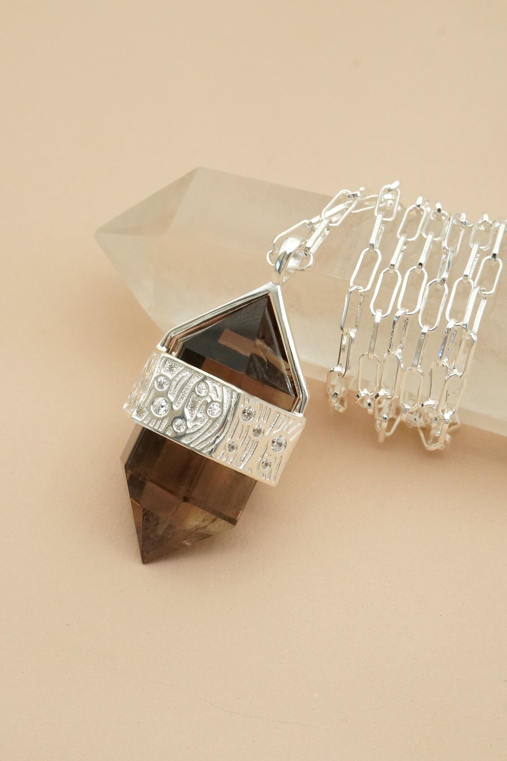 Silver Necklace with brown gemstone and tree design on a beige background