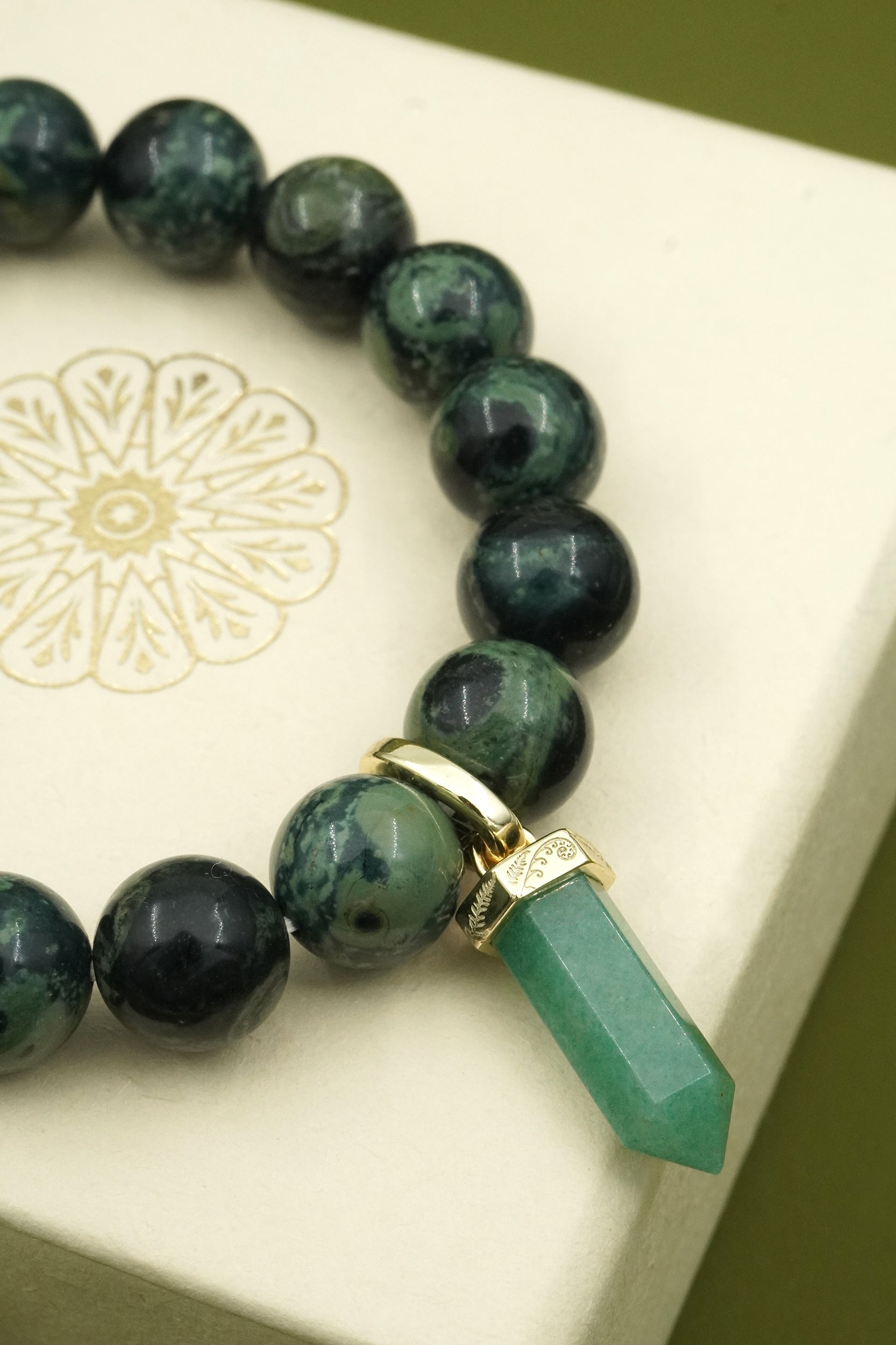 Green crystal beaded bracelet with a green aventurine gemstone on a white cloud nine jewellery gift box