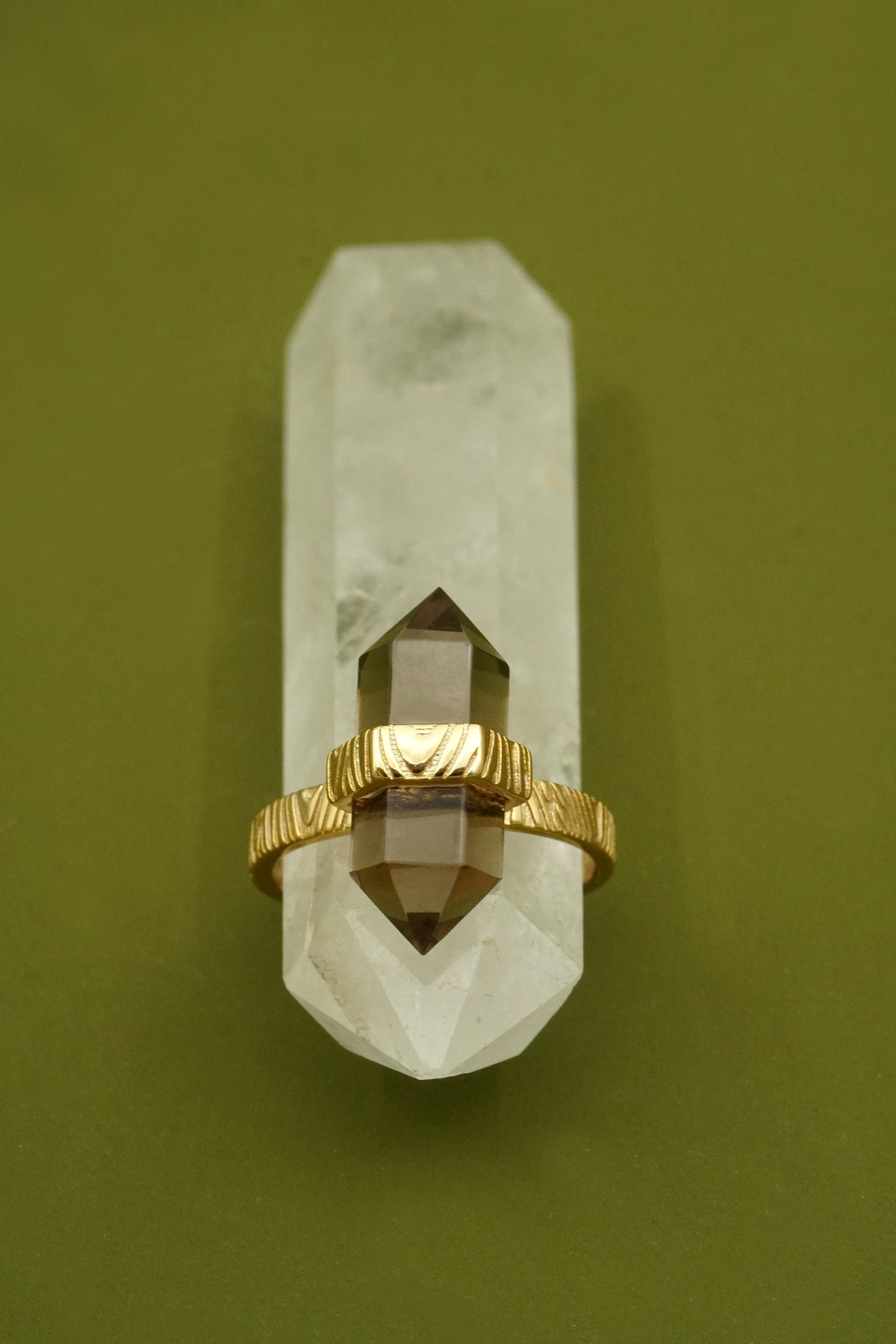 Gold ring on a crystal against a green background