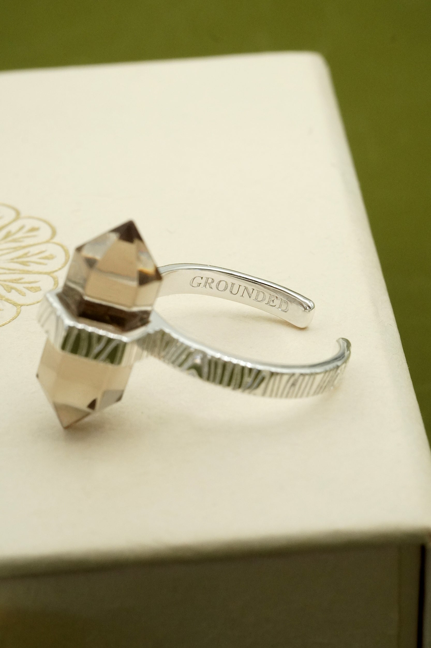 Silver ring with crystal on a beige box