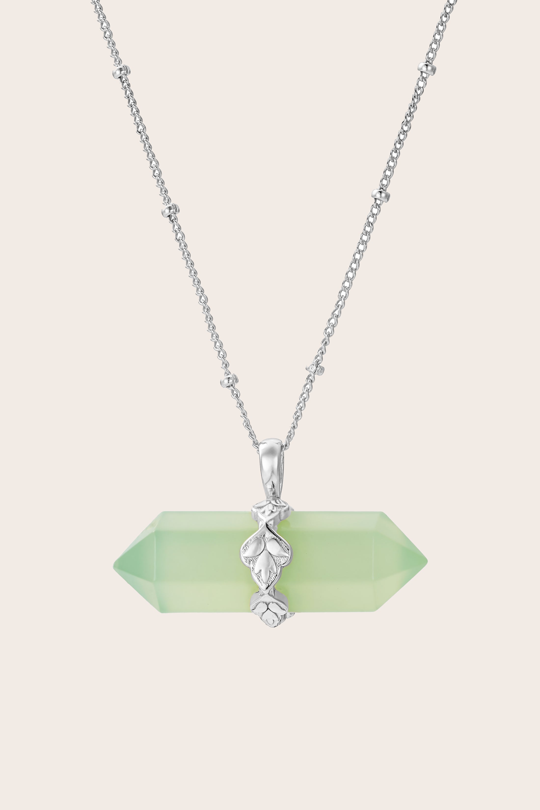 Necklace with a green jade pendant on a light beige background