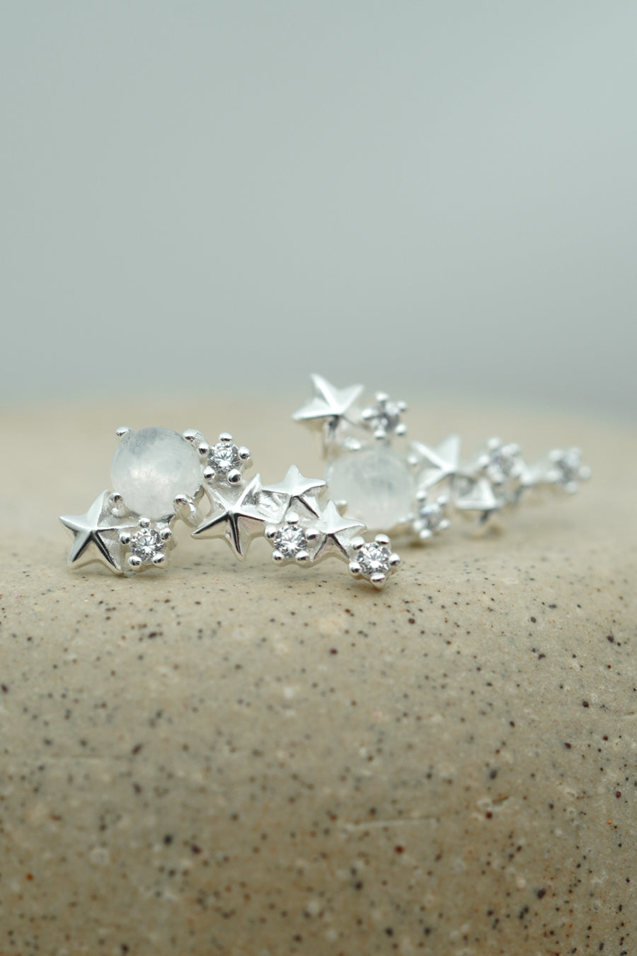 Silver Matariki Earrings Jewellery on textured background