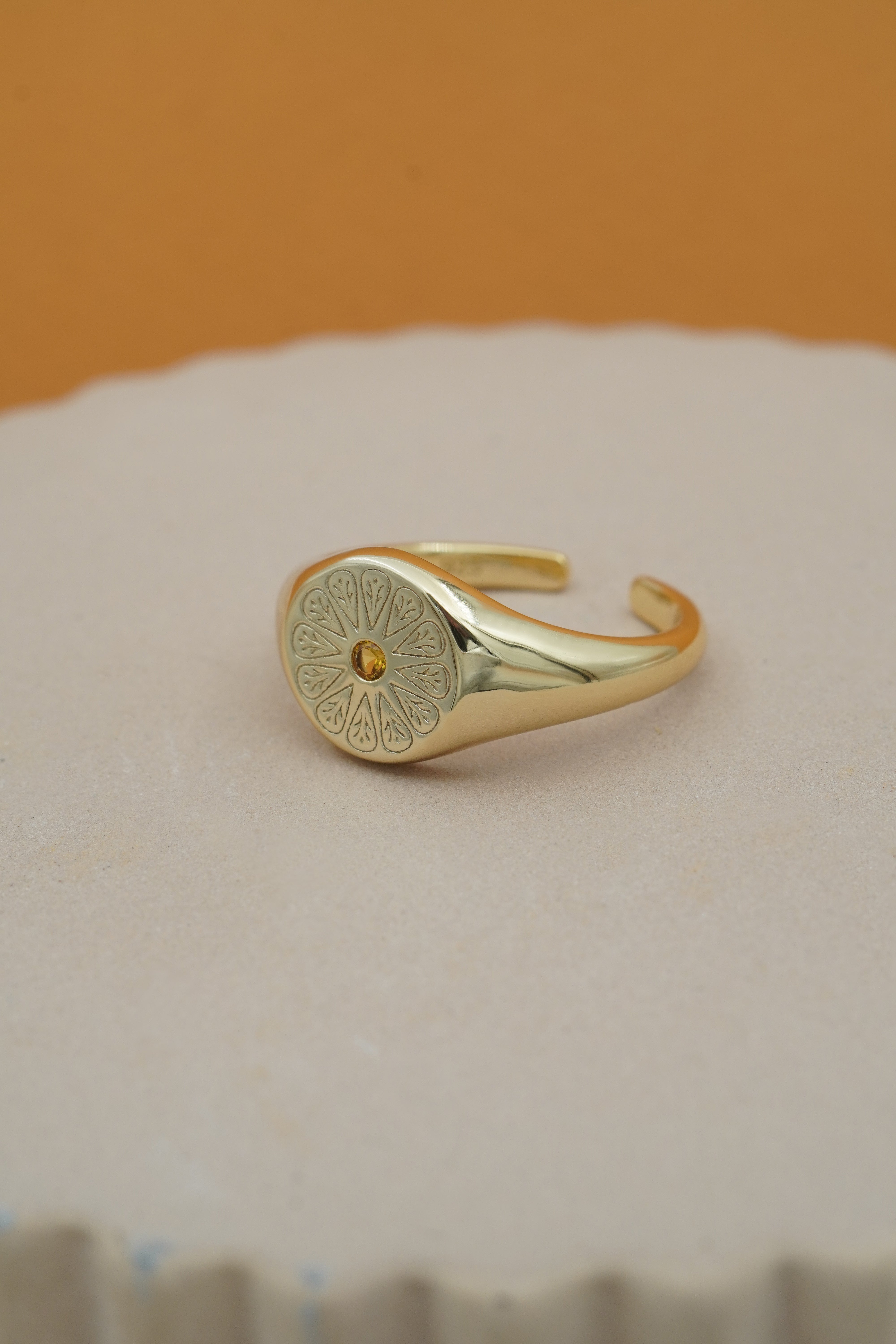 Gold Citrine November Signet Birthstone Ring on beige and orange background