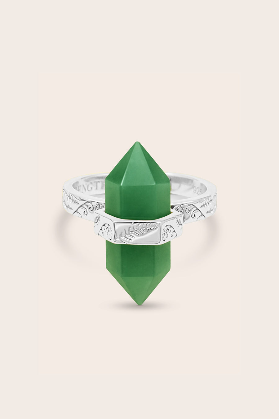 Green crystal point with silver band on a beige background