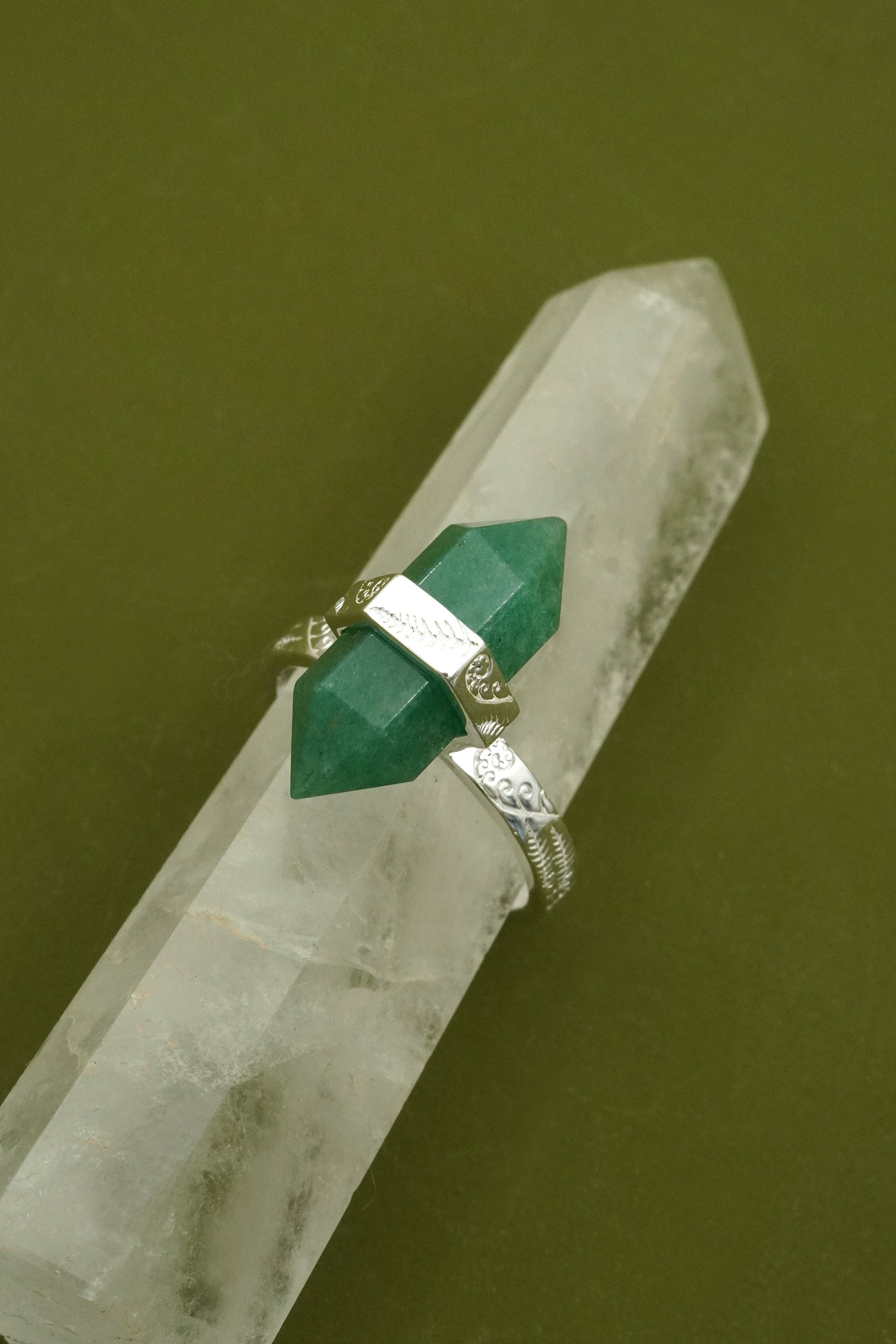 Green gemstone ring on a crystal with a green background