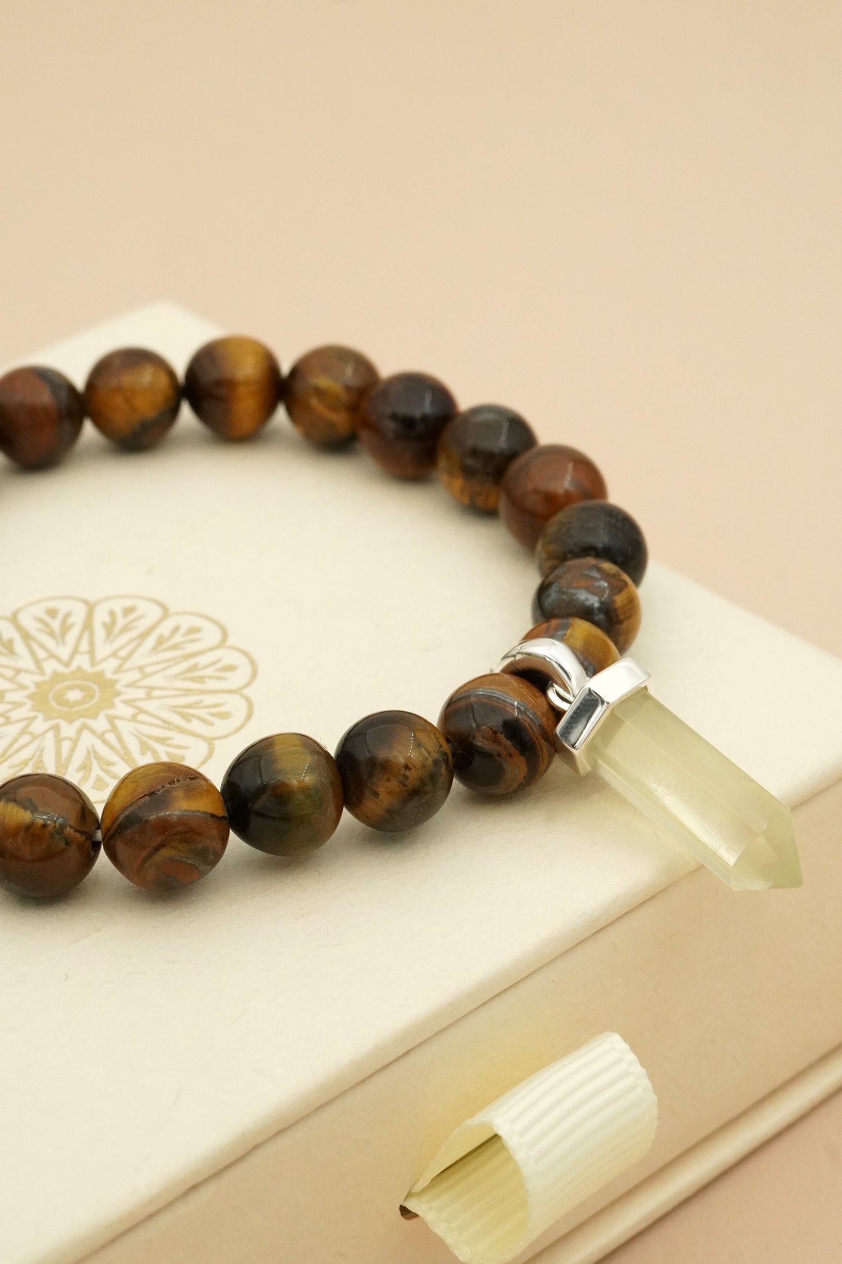 Bracelet with brown tigers eye beads on a beige surface