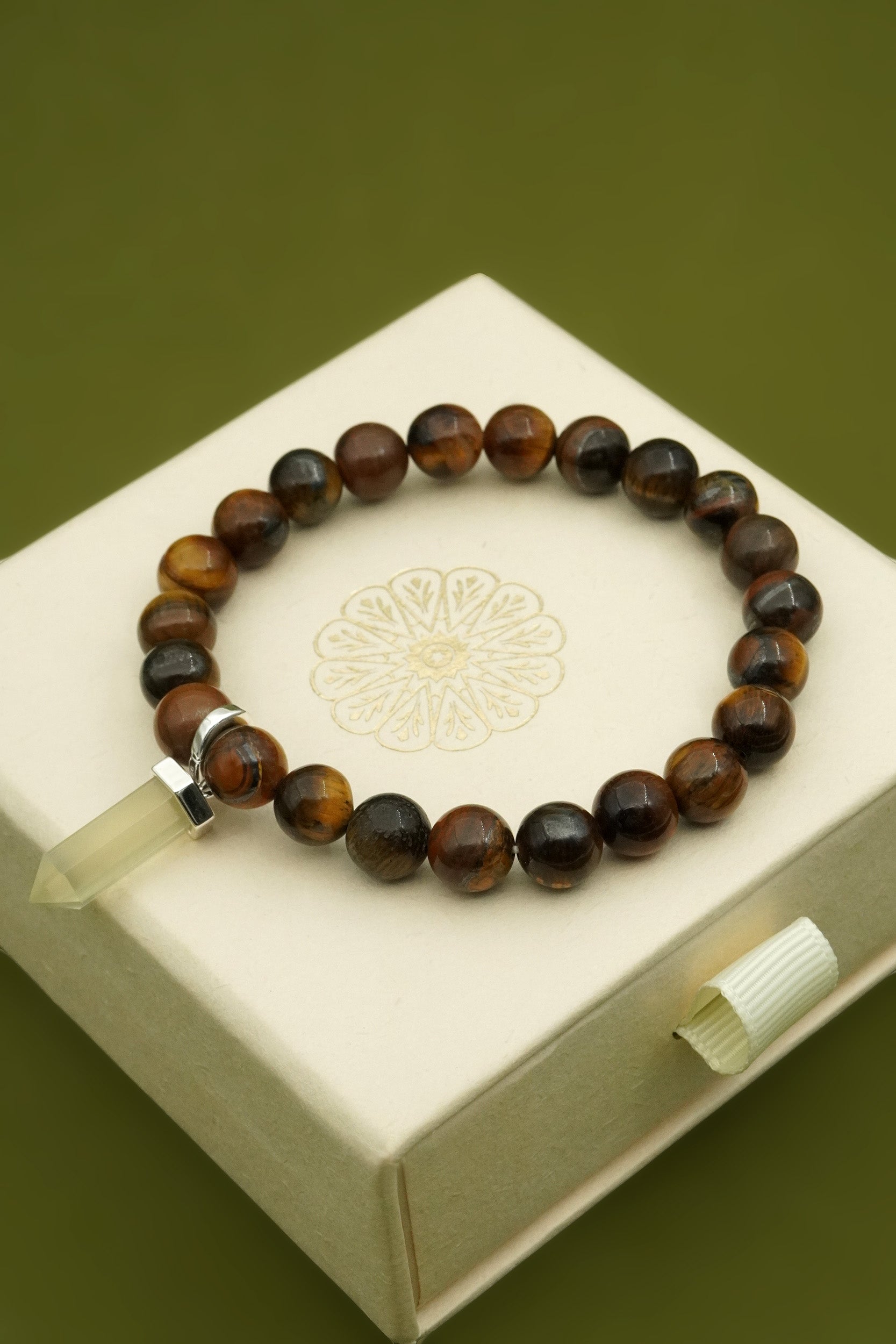 Beaded tiger's eye bracelet on a decorative cloud nine jewellery box with a green background