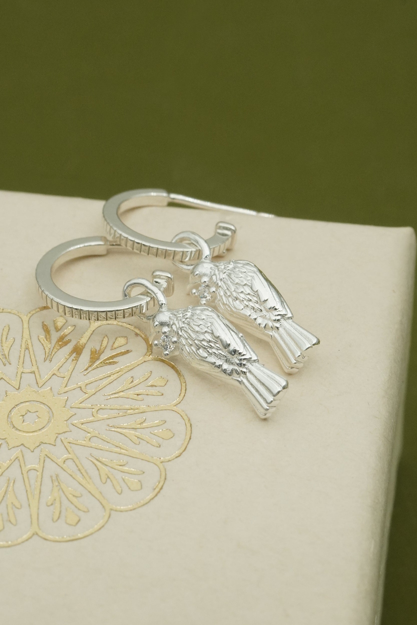 Silver Tui earrings with NZ bird charm on a decorative box
