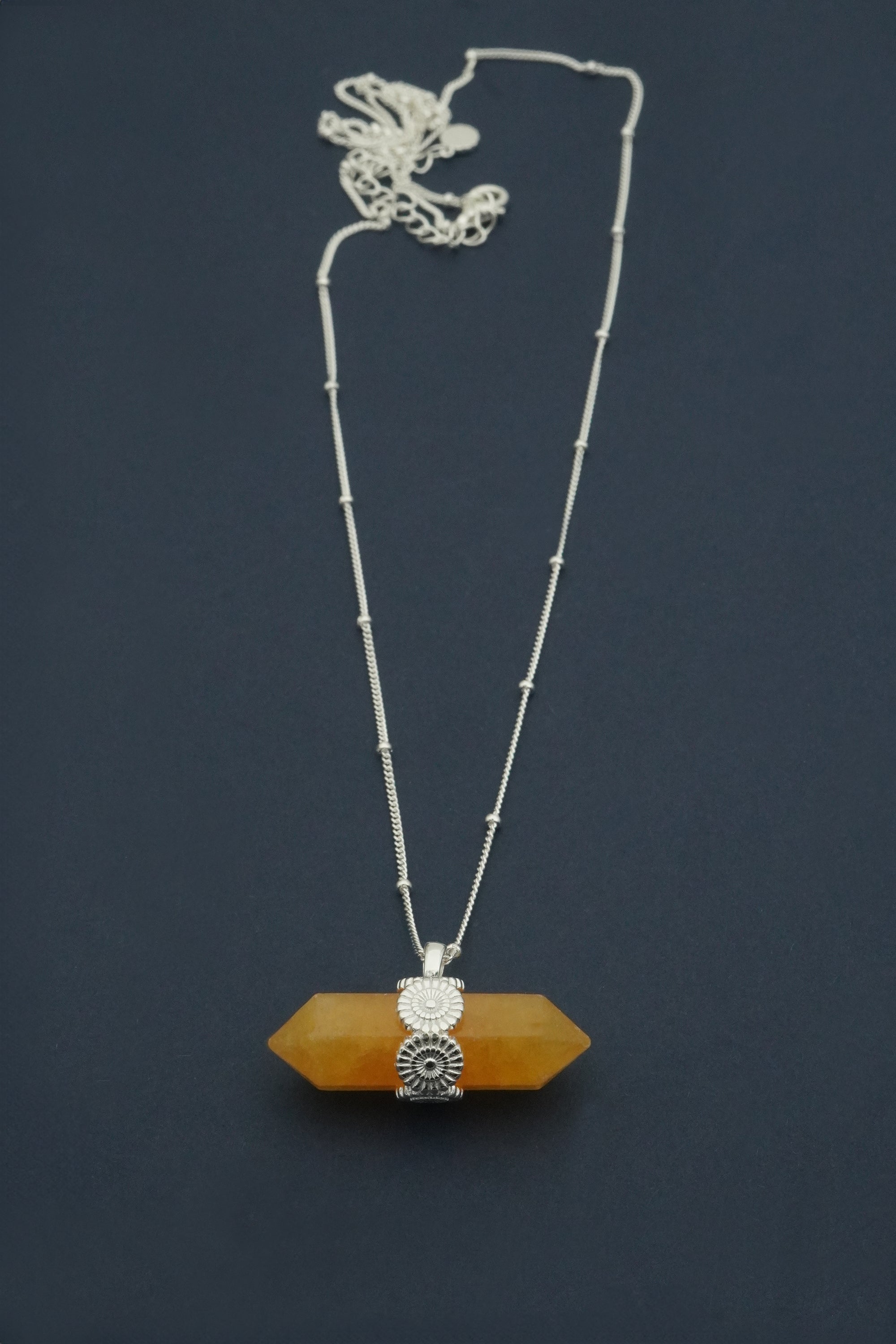 Necklace with a yellow crystal pendant on a dark background