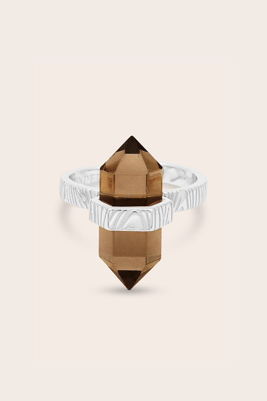 Ring with brown crystal and clear band on beige background