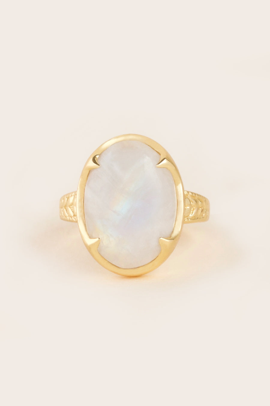moon ring made from rainbow moonstone and gold on cream background