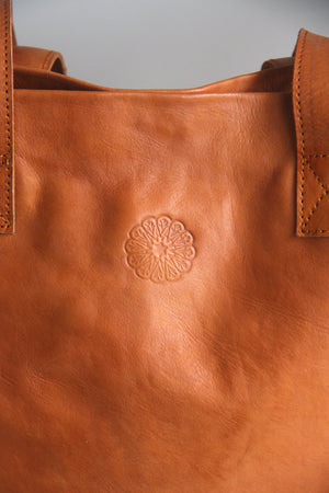Tan Leather Tote Bag with close up of stamped embossed mandala logo